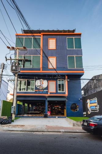 a blue building with a clock on the side of it at Phuket Marine Poshtel - SHA Plus in Chalong 