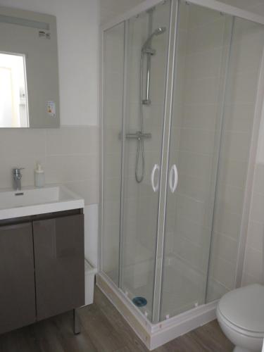une salle de bain avec une douche avec des toilettes et un lavabo dans l'établissement Appart Hôtel L'Angélique, à Saint-Nazaire