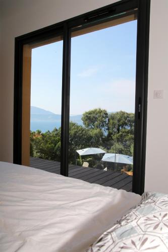 - une chambre avec un lit et une vue sur une terrasse dans l'établissement Villa Vue Mer, piscine chauffée, tennis, à Porticcio