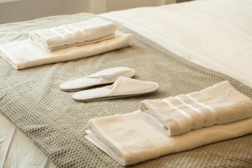 2 Handtücher und Flip-Flops auf einem Bett in der Unterkunft Hermes studio in Thessaloniki