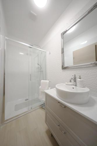 a white bathroom with a sink and a shower at Teatro Verdi Accommodation in Zadar