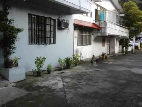 a white building with potted plants in front of it at JS3 Studio Apartments in Legazpi