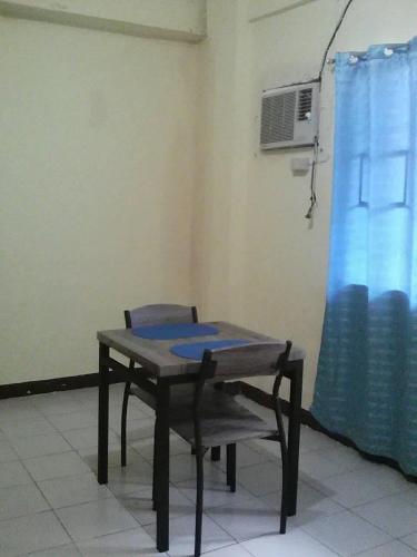 a table and a chair in a room with a fan at JS3 Studio Apartments in Legazpi