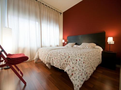 a bedroom with a bed and a large window at Apartamentos Murallas de Sevilla in Seville