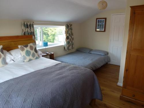 a bedroom with two beds and a window at Manor Farm Stay in Sutton on Sea