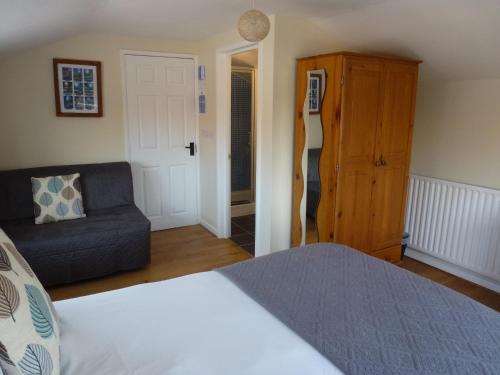 un dormitorio con una cama y un sofá en Manor Farm Stay, en Sutton-on-Sea