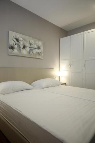 a white bed with two pillows in a bedroom at Teatro Verdi Accommodation in Zadar