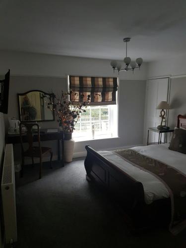 a bedroom with a bed and a desk and a window at The Boathouse in Sutton Bridge