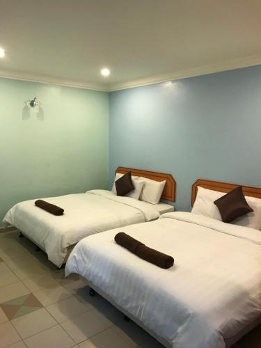 two beds sitting next to each other in a room at Hotel dan Restoran Seri Kangsar in Kuala Kangsar