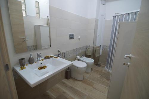 łazienka z białą umywalką i toaletą w obiekcie Triscele Casa Vacanze w mieście Portopalo
