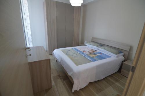 małą sypialnię z łóżkiem i drewnianą podłogą w obiekcie Triscele Casa Vacanze w mieście Portopalo