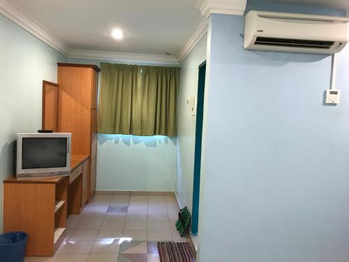 a living room with a tv and a room with a window at Hotel dan Restoran Seri Kangsar in Kuala Kangsar