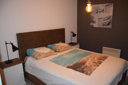 ein Schlafzimmer mit einem großen Bett mit zwei Kissen in der Unterkunft MIRAMAR Zeedijk 168 Blankenberge in Blankenberge