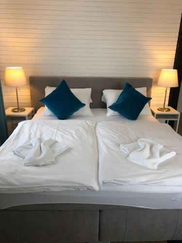 a bed with blue and white pillows on it at ZUM BAHNHÖFLE Restaurant & Hotel - Albbruck Am Rhein in Albbruck