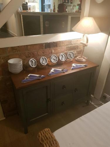 a room with a table with a lamp and plates at The Boathouse in Sutton Bridge