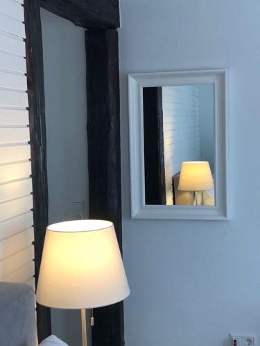 a room with a mirror and a lamp and a lamp at ZUM BAHNHÖFLE Restaurant & Hotel - Albbruck Am Rhein in Albbruck