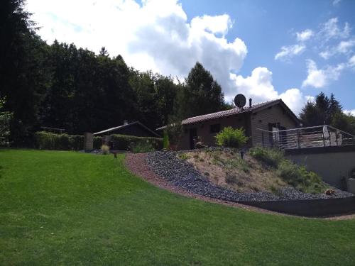 a yard with a house and a grass field at Ferienhaus "Haus Sommerstieg" in Waltershausen
