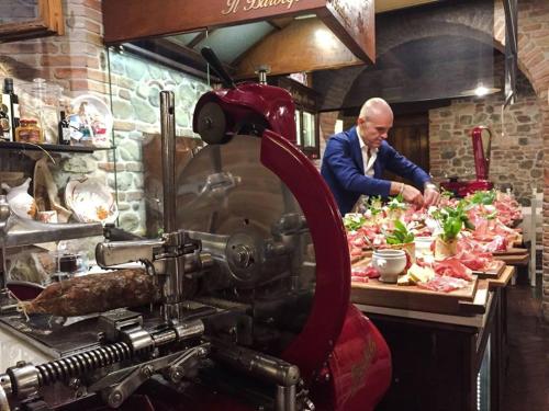 a man preparing food in a restaurant kitchen at Residenza i Platani in Santarcangelo di Romagna