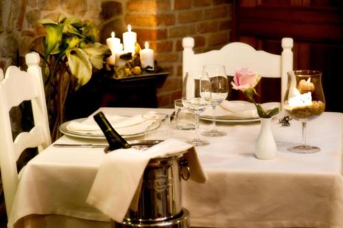 a table with a white table cloth and a flower on it at Residenza i Platani in Santarcangelo di Romagna