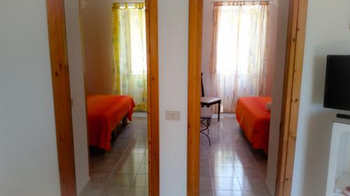 a room with two beds and a television in it at Appartamenti Luongo in Ischia
