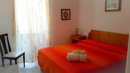 a bedroom with a red bed and a chair at Appartamenti Luongo in Ischia