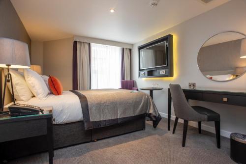 a hotel room with a bed and a mirror at Ten Hill Place in Edinburgh