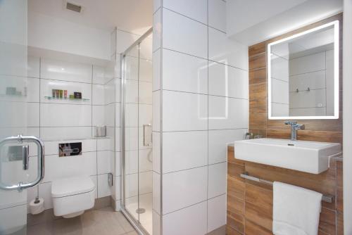 a white bathroom with a sink and a mirror at Ten Hill Place in Edinburgh