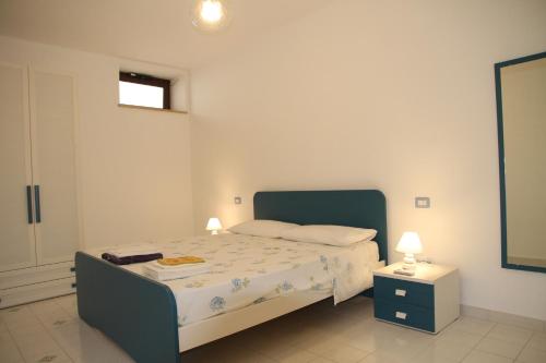 1 dormitorio con 1 cama y mesita de noche con 2 lámparas en Appartamento ZIBIBBO, en Canneto