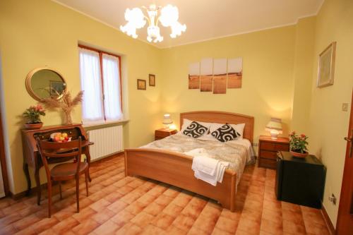 a bedroom with a bed and a table and a chair at Spighe Paglia e Girasole in Candia Canavese