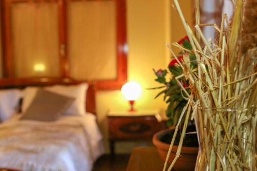 a bedroom with a bed and a vase with a plant at Spighe Paglia e Girasole in Candia Canavese