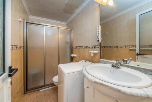 a bathroom with a sink and a toilet and a shower at Cosy Corner Playa del Inglés in Playa del Ingles