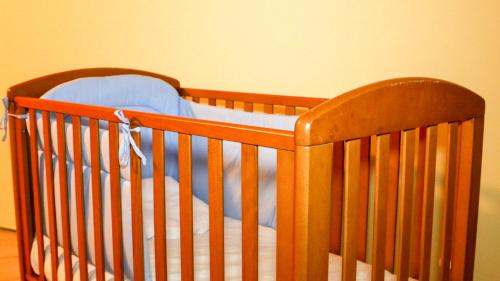 a wooden crib with a blue sheet on it at Spighe Paglia e Girasole in Candia Canavese