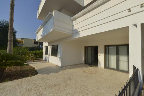 a white house with a patio and a fence at B&B dei Ciclopi in Salice Salentino
