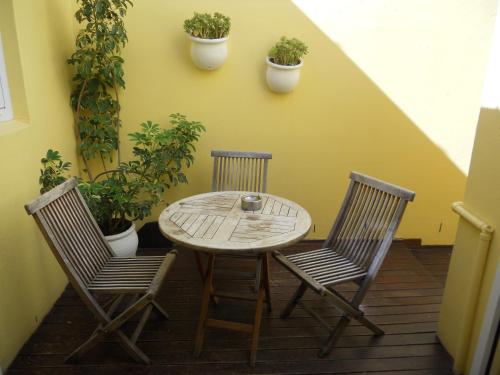 una mesa y dos sillas en un patio con plantas en Rose Lodge, en Ciudad del Cabo