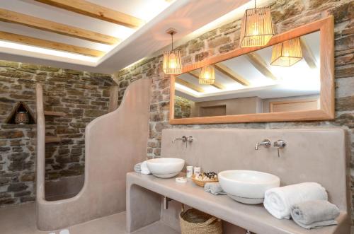 a bathroom with two sinks and a brick wall at Flora's Villa with Private Pool in Agkidia