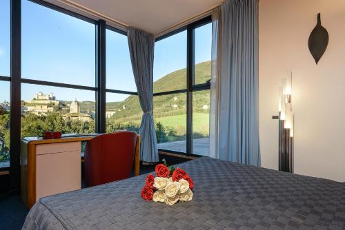 a bedroom with a table with flowers on it at Albornoz Palace Hotel in Spoleto