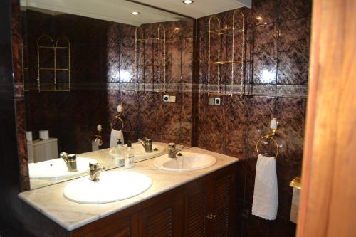 Un baño con dos lavabos y un espejo grande. en Casa Santo Tomé, en Toledo