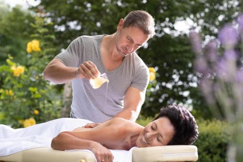 a man is giving a woman a massage at Thermenhotel PuchasPLUS Stegersbach in Stegersbach