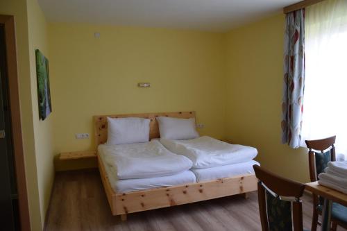 a bedroom with a bed with white sheets and pillows at Der Schildbacherhof in Hartberg