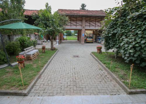 a brick walkway in a garden with a pavilion at Spighe Paglia e Girasole in Candia Canavese