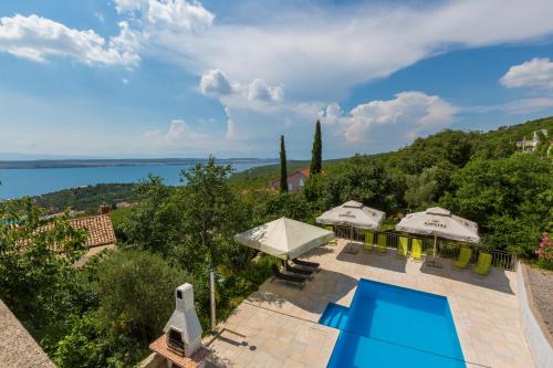 an image of a villa with a swimming pool and umbrellas at Apartments Slavica in Dramalj