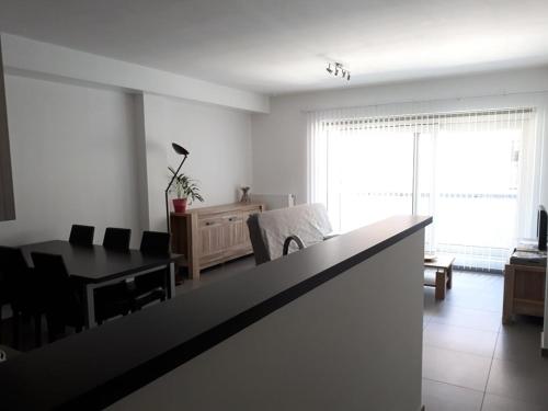 a living room with a table and a dining room at Residentie Koen in Ostend