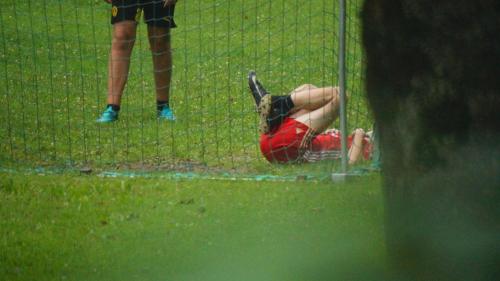 a person laying on the ground in a batting cage at Ferienwohnungen Dzido in Hermagor