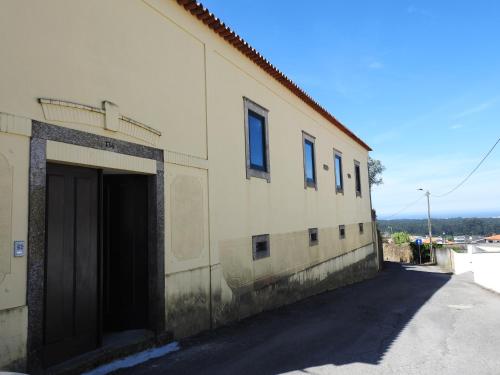 a building with a garage next to a street at Casa da Aldeia MGS in Laundos