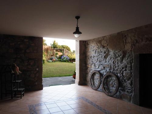 a hallway with a stone wall with two largewheels at Casa da Aldeia MGS in Laundos