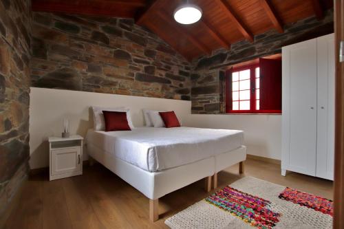 a bedroom with a bed and a brick wall at Casa do Ocreza in Sobral Fernando