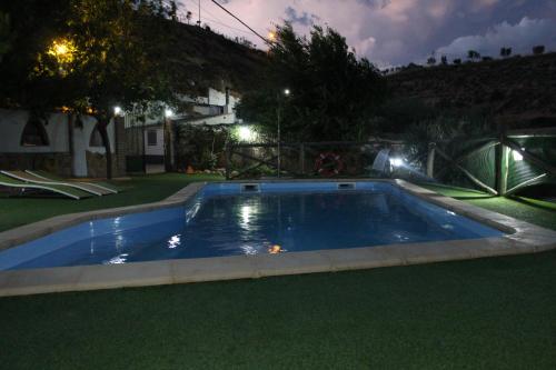 a swimming pool in a yard at night at Casas Cueva Cazorla in Hinojares