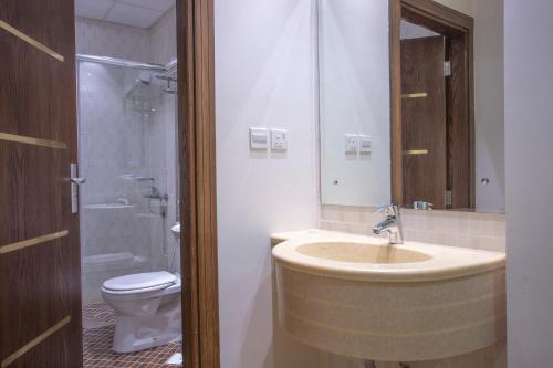 La salle de bains est pourvue d'un lavabo et de toilettes. dans l'établissement Sand Beach Suites(Families only), à Rayyis