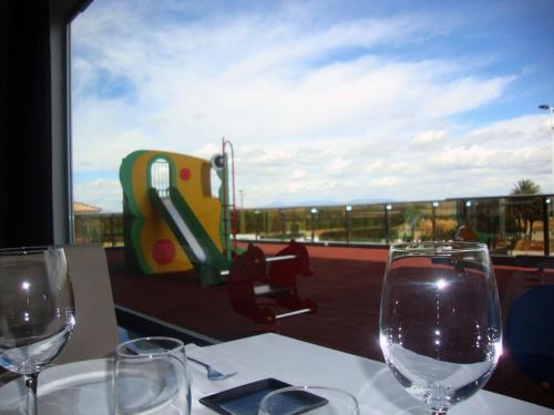 two wine glasses sitting on a table with a view at Dña Monse Hotel Spa & Golf in Torrevieja