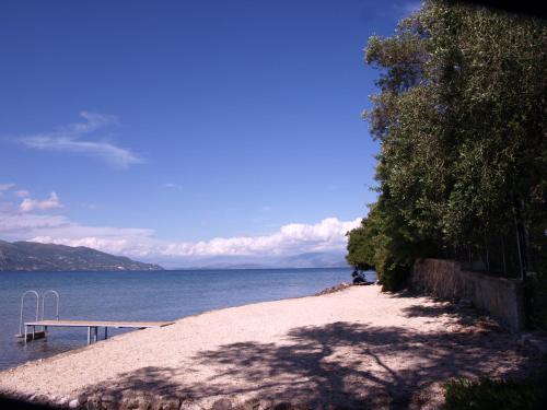 a sandy beach next to a body of water at Saint Nicholas Beach Resort in Dassia